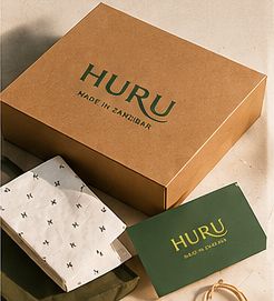 Natural kraft HURU box with a printed tissue wrap and a deep green HURU card