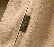 Small green HURU tag stitched into the side seam of natural linen