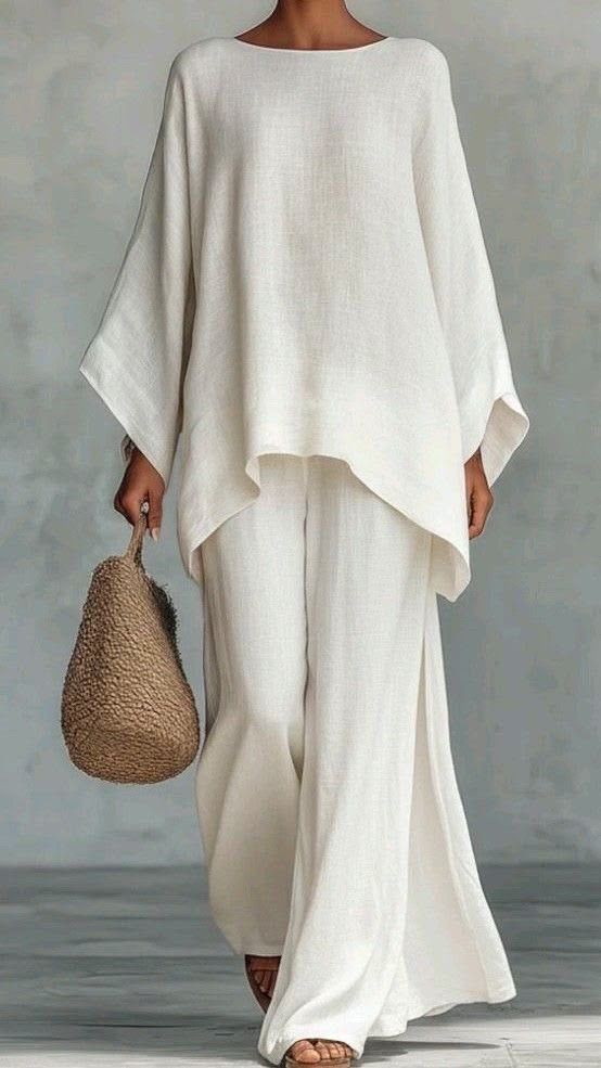 Woman in an oversized white linen top and wide trousers